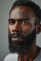 Obraz premium Profile portrait of young hadsome serious bearded African American man on the grey background