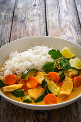 Chicken nuggets with rice and vegetables on wooden table
