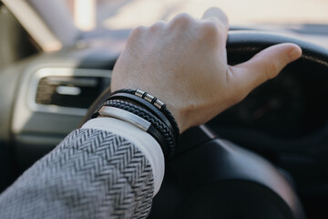 Leather bracelet on the male driver hand - 703882044