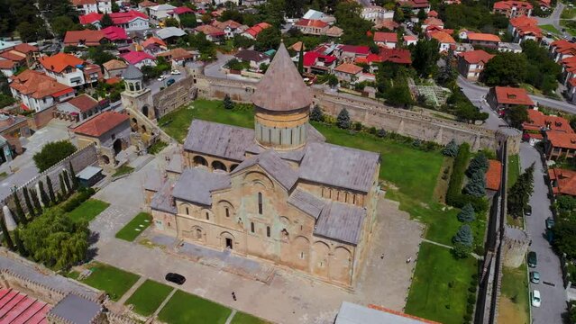Beautiful aerial view of streets of Mtskheta village in Georgia. Mtkvari river. Summer sunny day. Travel and vacation. Svetitskhoveli Cathedral fortress in the center.