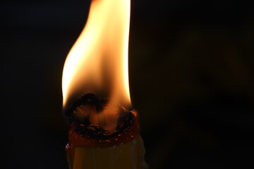 candle burning match on black background