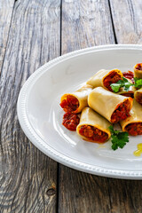 Paccheri con ragù alla bolognese - noodles with bolognese  sauce on wooden table
