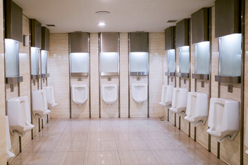 A very clean pubilc toilet room with urinals attached to the wall