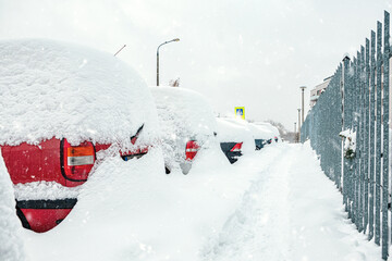 Poland, Krakow, 12.03.2023, snowfall, snowy street with cars after a blizzard