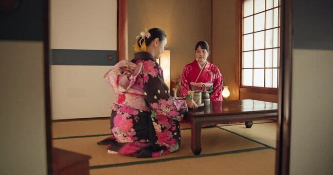 Japanese women, traditional tea ceremony and friends with respect, kindness and relax with bow at table. Girl, people and together for drink, matcha or indigenous clothes with cup, culture and home