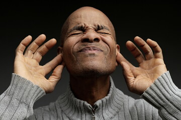 deafness suffering from hearing loss on grey black background with people stock image stock photo	
