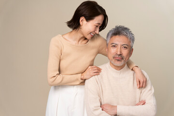 日本人ミドル世代夫婦のポートレート/男性の肩を抱き微笑んでいる女性