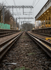 Fototapeta na wymiar Railway iron rails from the low perspective. Railroad tracks with limited depth of focus, The Railway system with Metal frames of Train platform, Railroad track rails, Train tracks, Railway station, S