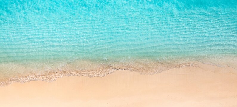 Sunny gold sandy beach, panorama. Panoramic view tranquil sandy beach. Peaceful sea waves shore. Ocean coast view. Aerial photography beachfront. Seaside exotic tropical Mediterranean nature landscape © icemanphotos