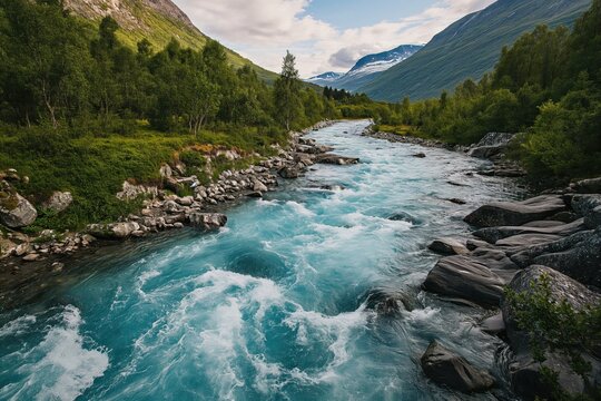 Drone high-angle photo of the turquoise-colored mountain river flowing in the pine woodland with a view of the mountain peaks in the background in Innlandet County, Norway 