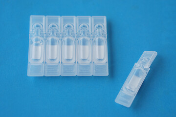 Single use artificial tear lubricant eye drops containers, tubes, isolated on blue  background....