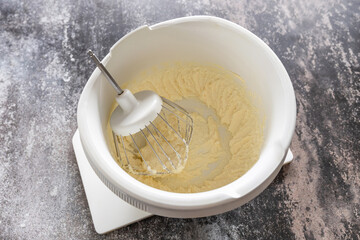 Cooking Glazed easter lemon cake decorated with confectionery and mini chocolate eggs candy on gray stone background, step by step, step 1.