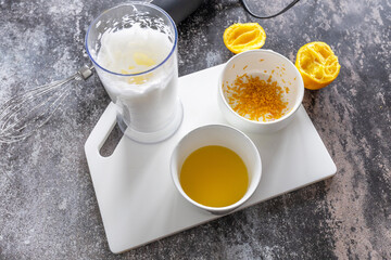 Cooking Glazed easter lemon cake decorated with confectionery and mini chocolate eggs candy on gray stone background, step by step, step 3
