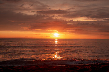 Naklejka na ściany i meble Beautiful view of the sea sunset. Orange evening sky.