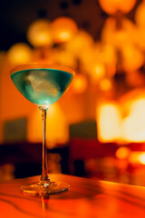 One delicious ice cold cocktail in exquisite glasses stand on a wooden table in a restaurant