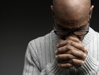 man praying to god Caribbean man praying with black grey background with people stock photo
