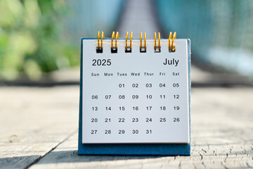 July 2025 white calendar with green blurred background. New year concept.
