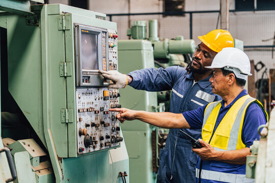 Industrial worker indoors in old factory. Industrial man Engineers in Hard Hats.Work at the Heavy Industry Manufacturing Factory. - Powered by Adobe