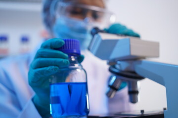 Science test tubes, laboratory equipment for new medical research, microbiology research with small pipettes in close-up. Asian and African female scientists in the laboratory, perfume samples