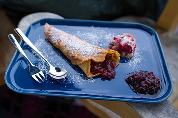 delicious pancakes with cranberries, ice and powder sugar served on a blue plate