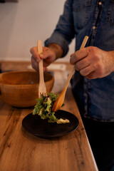 Man Cooking Green Salad Of Romaine Lettuce. Healthy Food concept