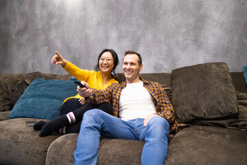 Couple Watches TV together while Sitting on a Couch in the Living Room. Girlfriend and Boyfriend...