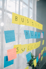 Young creative team professional using post it notes in glass wall to writing strategy business plan to development grow to success.