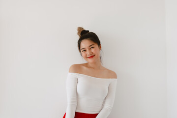 Beautiful Asian Thai woman wear open shoulder with bun hair and red lips, happy smiling and looking...
