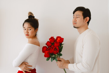 Asian man giving red rosed and flirting, begging for love on valentines day, apologizing woman...
