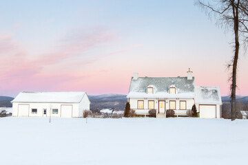 Sunrise winter view of steep shingled roofed patrimonial white wooden house and barn with...