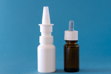 Fototapeta na wymiar Bottles with drops and spray nasal drops on background. Medicine for cold
