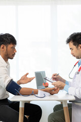 Asian male doctor talking with male patient in office Focus on the brain simulator on the table health care concept