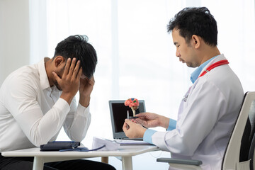Asian male doctor talking with male patient in office Focus on the brain simulator on the table health care concept