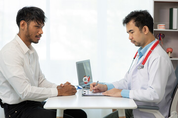 Close-up of an Asian male doctor showing an eyeball model and explaining eye diseases to a male patient in hospital. health care concept