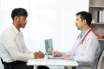 Obraz premium Close-up of an Asian male doctor showing an eyeball model and explaining eye diseases to a male patient in hospital. health care concept