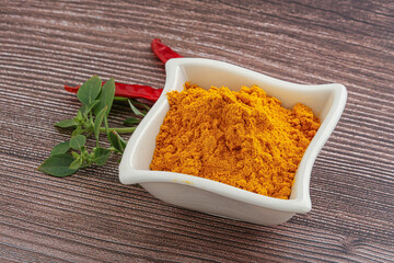 Yellow vibrant curcuma powder in the bowl