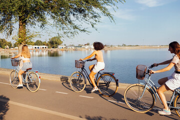 Fototapeta premium Teenagers of different nationalities and appearance on bicycles ride along a city street
