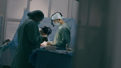 Process of trauma surgical operation professional team medical nurses doctors surgeons perform heart surgery neurosurgery in sterile operating room with equipment modern hospital emergency saving life - Powered by Adobe