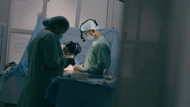 Process of trauma surgical operation professional team medical nurses doctors surgeons perform heart surgery neurosurgery in sterile operating room with equipment modern hospital emergency saving life