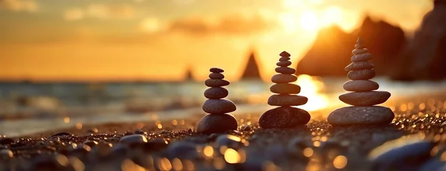 Gartenposter Steine ​​im Sand Pebble stacks balance on a beach at sunset. The stacked stones stand in harmony against ocean. Gentle waves wash over the shore, tranquil rock formations.