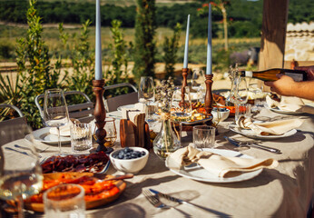 hairs and a table for guests, decorated with candles, are served with cutlery and crockery