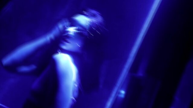 seductive woman stripper dancing in nightclub, laser show in darkness, female silhouette