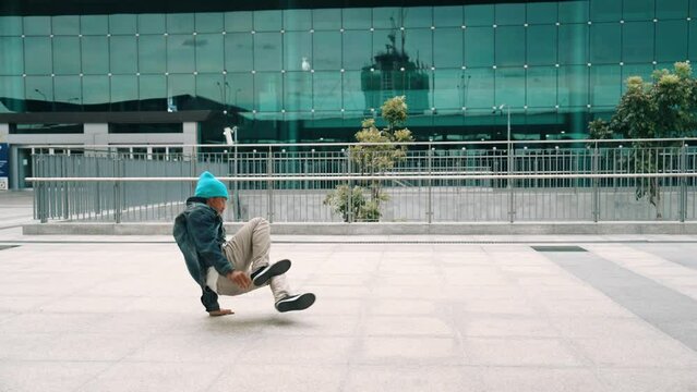 Happy hipster listen to hip hop music from headphone while dancing in lively mood. Professional street dancer perform b boy dancing at outdoor. Outdoor sport 2024. Modern lifestyle. Sprightly.