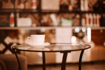 Hairdressing salon interior. Coffee cup on glass table and chair for client in beauty parlor with nobody