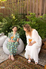 Happy female friends spending time together, young woman drinking Aperol spritz