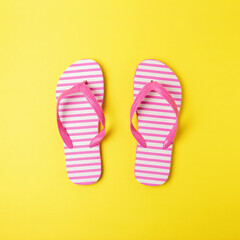 Creative composition with beach slippers on yellow background. Summer minimal concept.