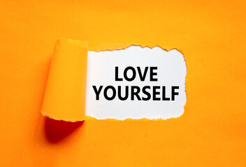 Love yourself symbol. Concept words Love yourself on beautiful white paper. Beautiful orange paper background. Psychology love yourself concept. Copy space.