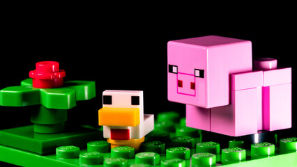 Fototapeta premium LEGO Minecraft pig and duck on a green meadow next to a red flower
