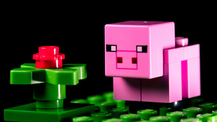 Obraz premium LEGO Minecraft pig on a green meadow next to a red flower