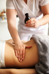 Crop masseuse using massage oil during skincare procedure